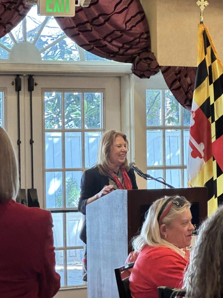 Maryland State Senator Mary Beth Carozza (District 38) speaks at a podium next to a Maryland state flag during the Red Scarf Day 2025 event
